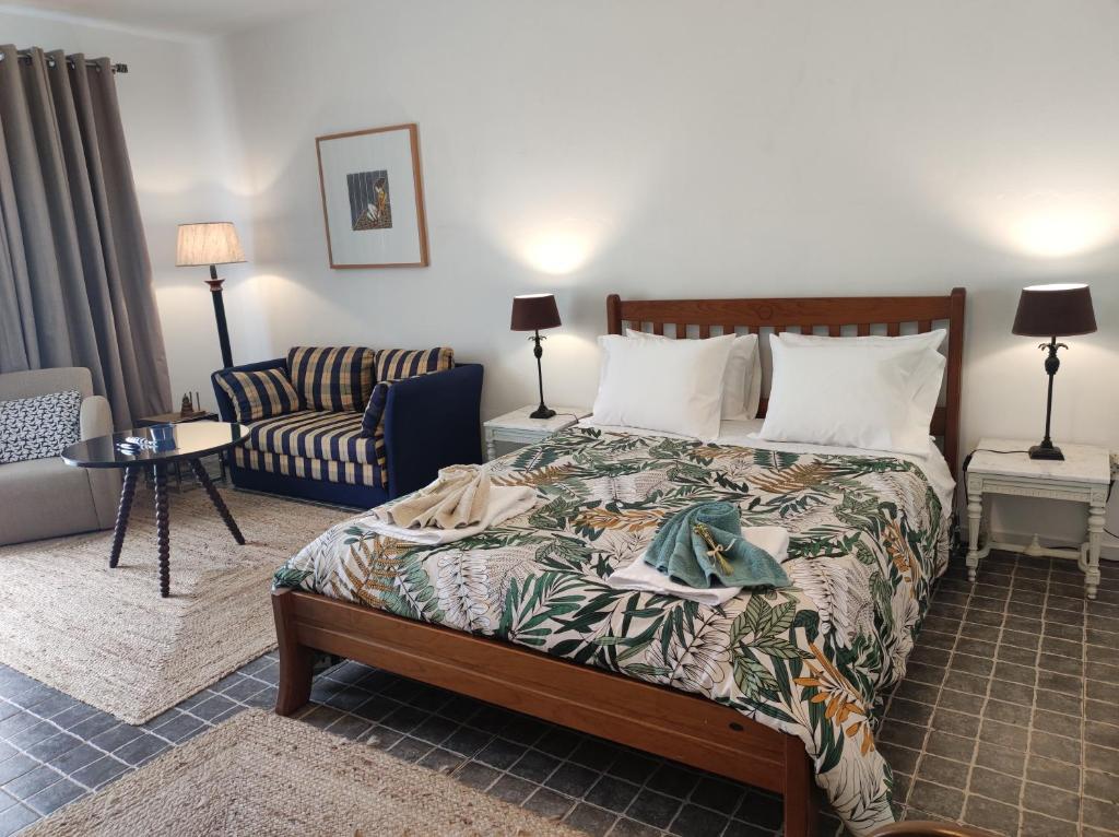 una camera d'albergo con letto e divano di Quinta dos Chorões a São Vicente Ferreira
