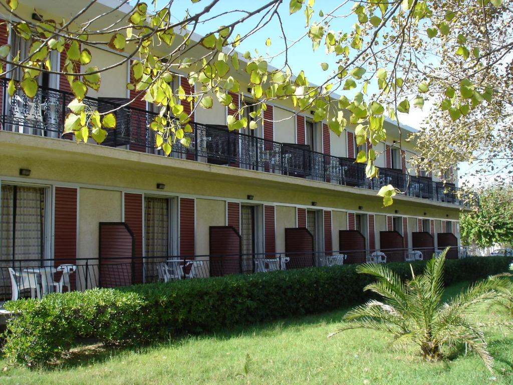 an apartment building with tables and chairs on the balcony at Stella Studios in Laganas
