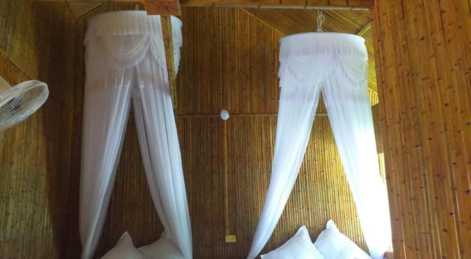 Twee witte broeken hangen aan een muur. bij Homestay Chung Thêm in Hoàng Su Phì