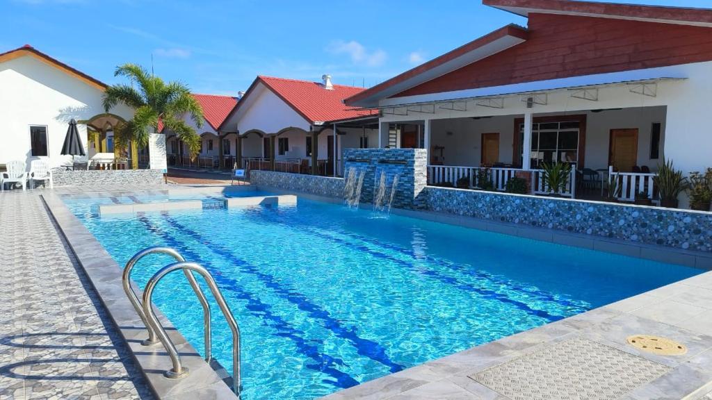 a swimming pool in front of a house at The Nutshell Chalet Langkawi in Pantai Cenang