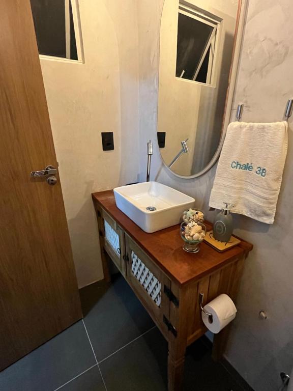 ein Badezimmer mit Waschbecken und Spiegel in der Unterkunft Chalé Paraíso -Maracajaú 4- Casa 38 - Beira-mar in Maxaranguape