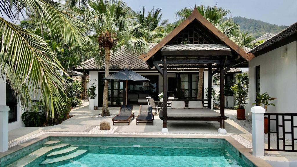 een villa met een zwembad en een huis bij 3 Bedroom Seaview Villa Halo on Beachfront Resort in Koh Samui 