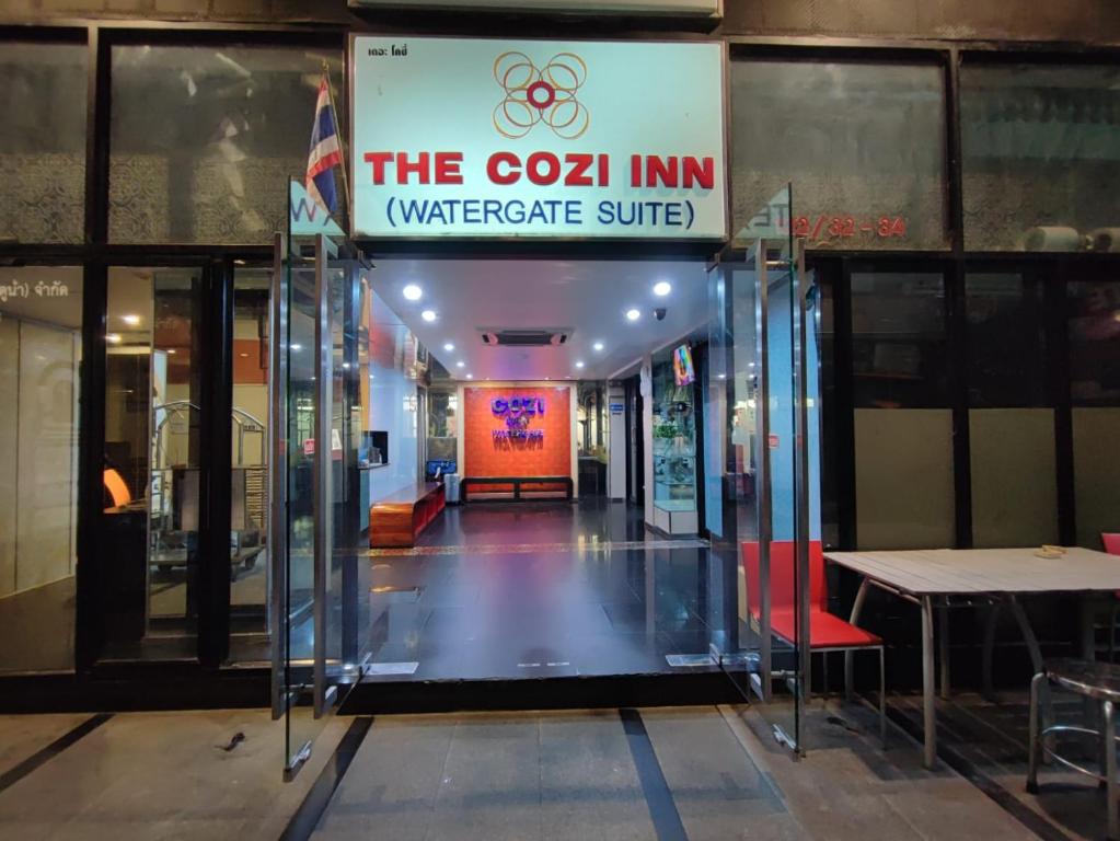 un ingresso a un edificio con un cartello per la locanda di Cozi Inn Hotel, Bangkok a Bangkok