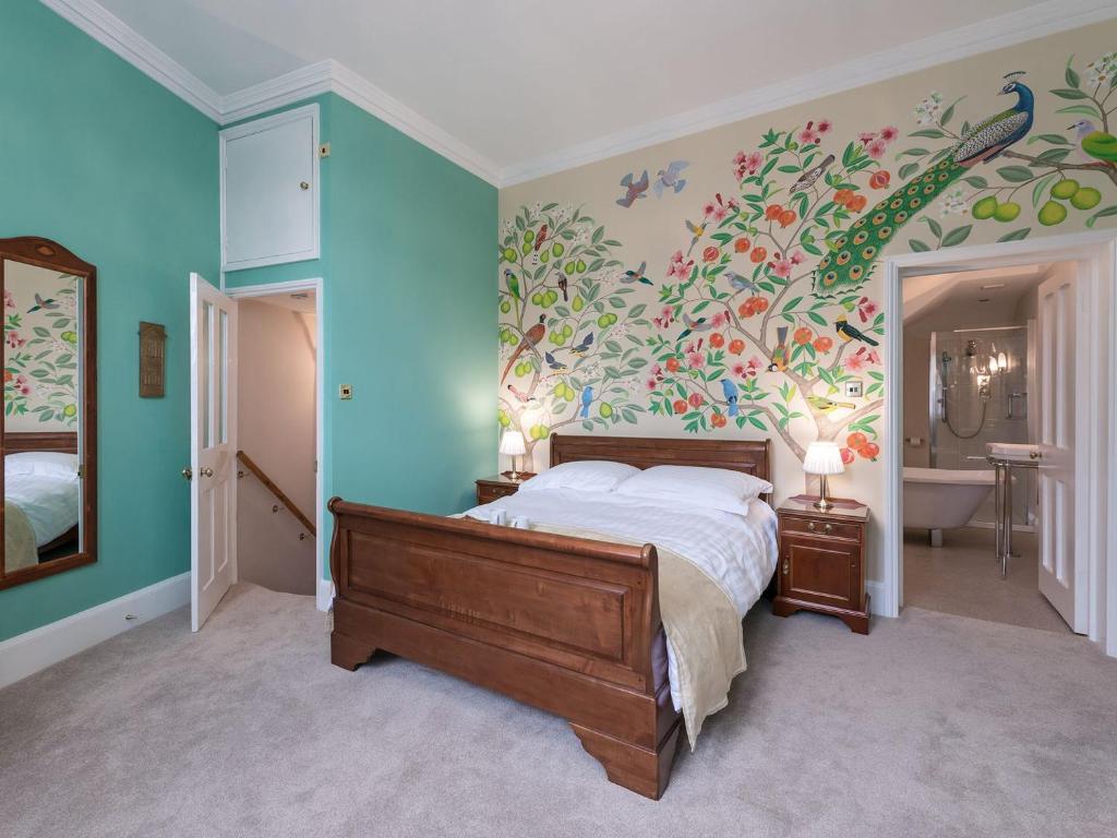 a bedroom with a bed with a floral wall at The Counting House in Wirksworth