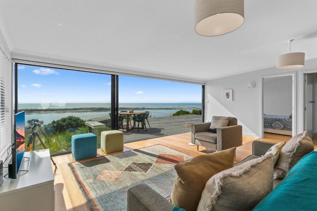 ein Wohnzimmer mit Blick auf das Meer in der Unterkunft Blue Skies Sunrise - Mangawhai Heads Holiday Home in Mangawhai