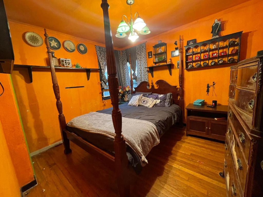 a bedroom with a bed in a room with orange walls at Castle Zoe in Vallejo