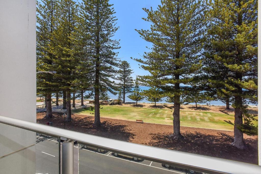 uma janela com vista para um parque com árvores em 25 The Breeze - unit 25 at nr 2-5 Flinders Pde, Victor Harbor em Victor Harbor