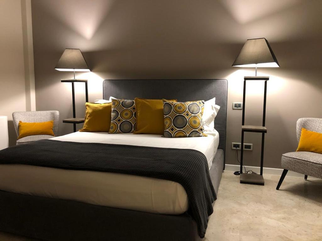LAUS VIA SPARANO APP.2- LUX & DESIGN NEW! في باري: غرفة نوم بسرير كبير فيها مصباحين وكرسيين
