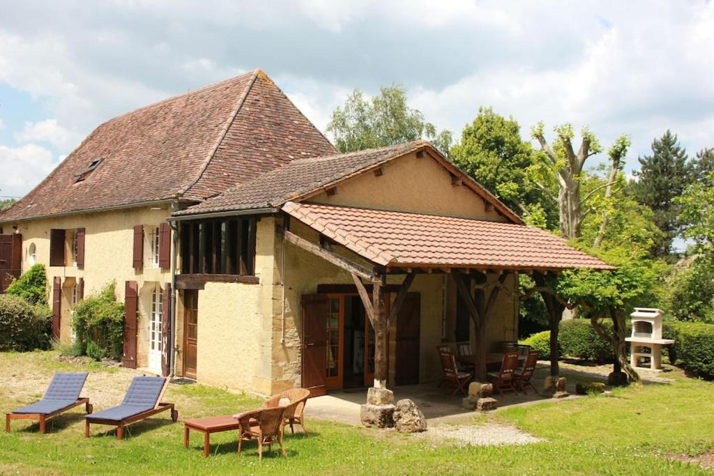 ein kleines Haus mit Stühlen und einem Dach in der Unterkunft Le Cireysou - Secluded farmhouse with large private pool and grounds in Saint-Germain-et-Mons