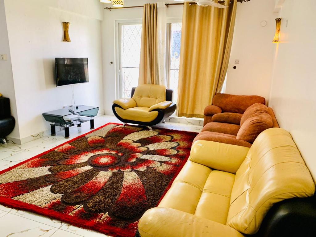 a living room with a couch and a rug at Lux Suites 3 Bedroom Hydro Apartments Nyali in Mombasa