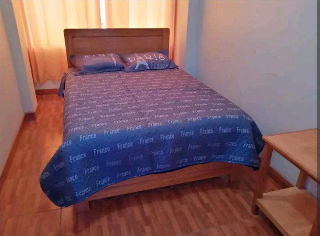 a bedroom with a bed with a blue comforter at Hospedaje Sumita Wasi in Puno