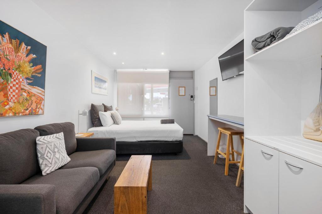 a living room with a couch and a bed at Moody's Motel in Blairgowrie