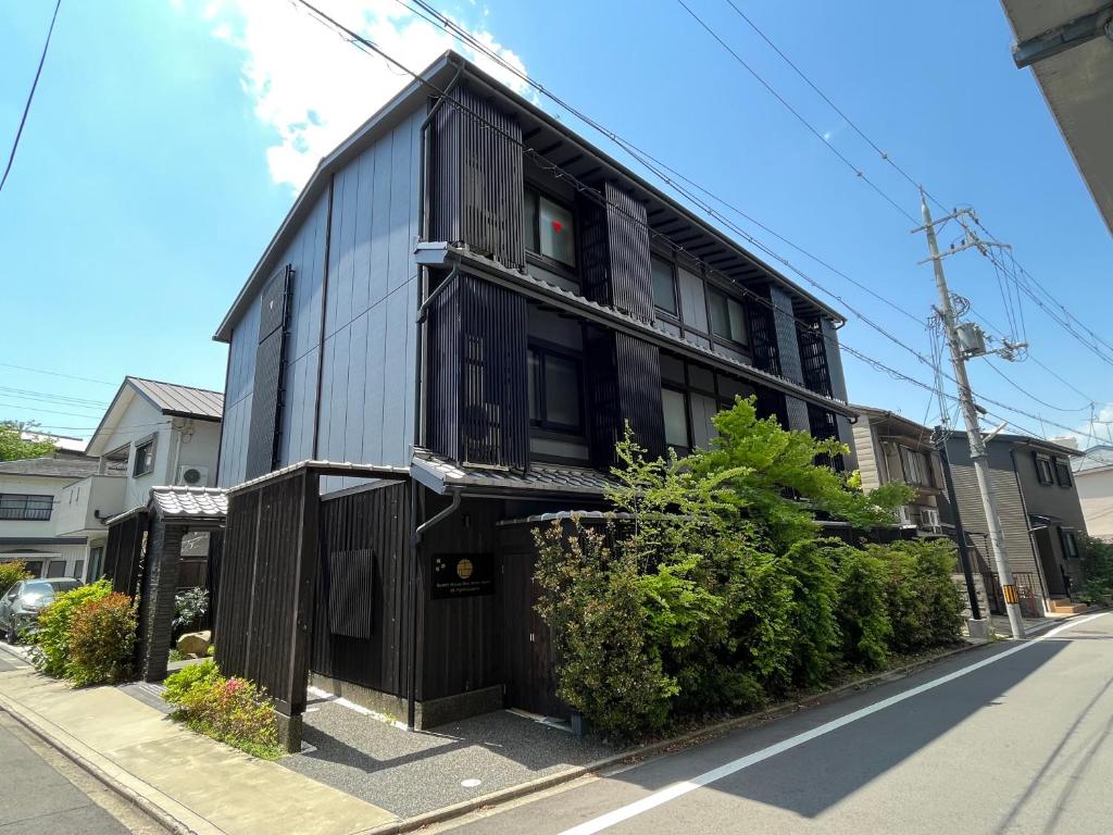 a black house on the side of a street at Guest One More Heart at Higashi Otowa in Gionmachi