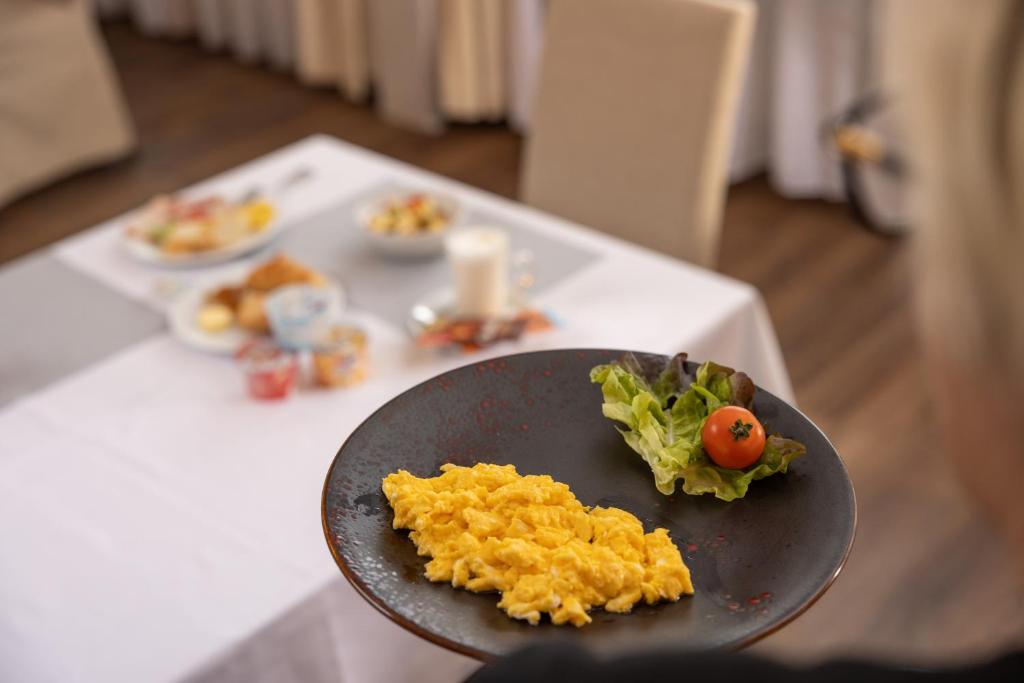 a table with a plate of food on a table at Adhhoc Hotel in Naters