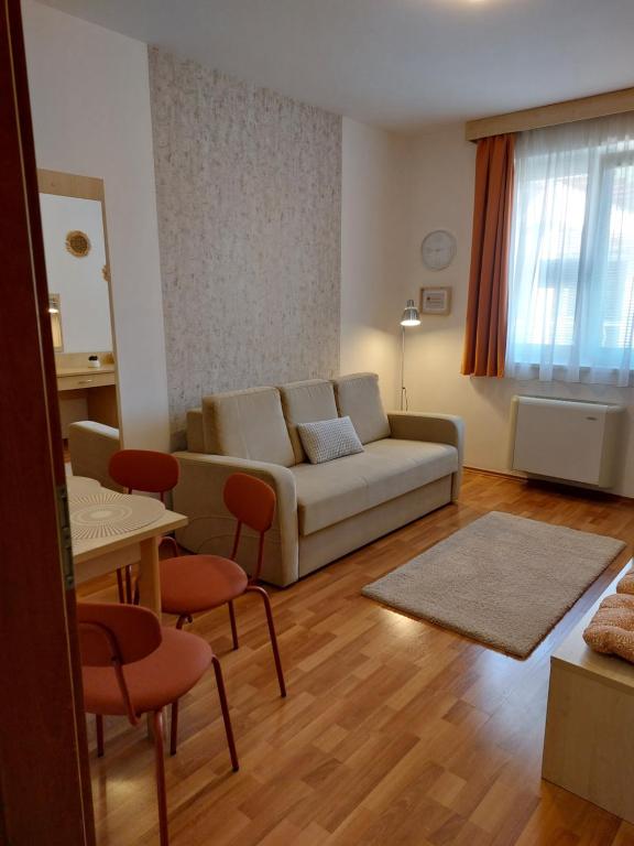 uma sala de estar com um sofá e uma mesa em MyRelax Apartment em Hajdúszoboszló