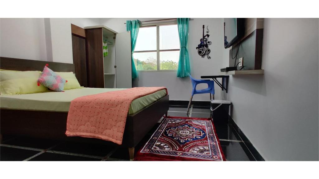 1 dormitorio con cama, ventana y silla azul en Anyhour Stay, en Gannavaram