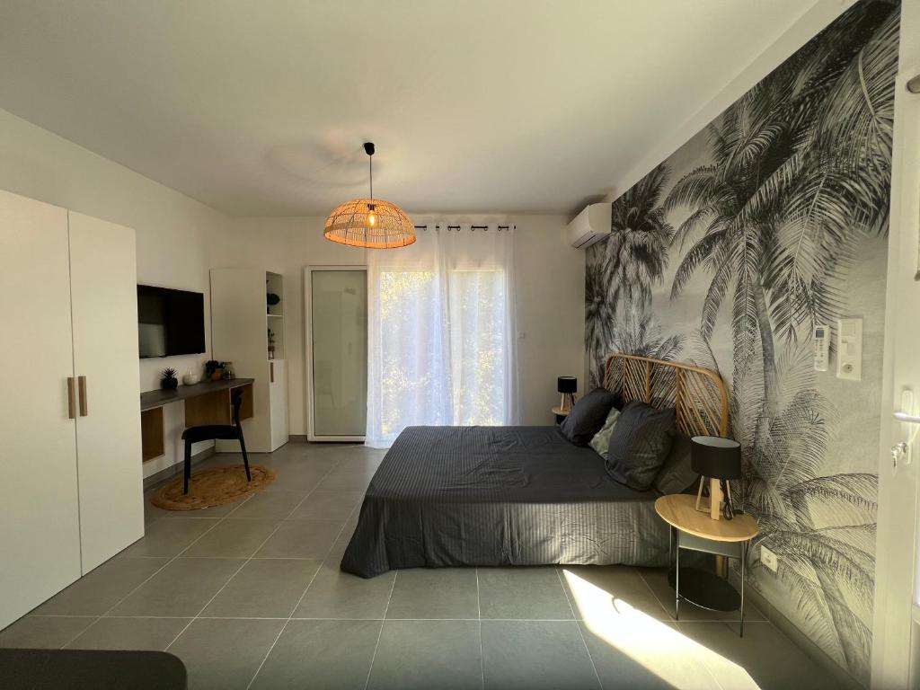 - une chambre avec un lit orné d'une fresque murale en palmier dans l'établissement Grand studio - Ajaccio - Salario - Capo di feno, à Ajaccio