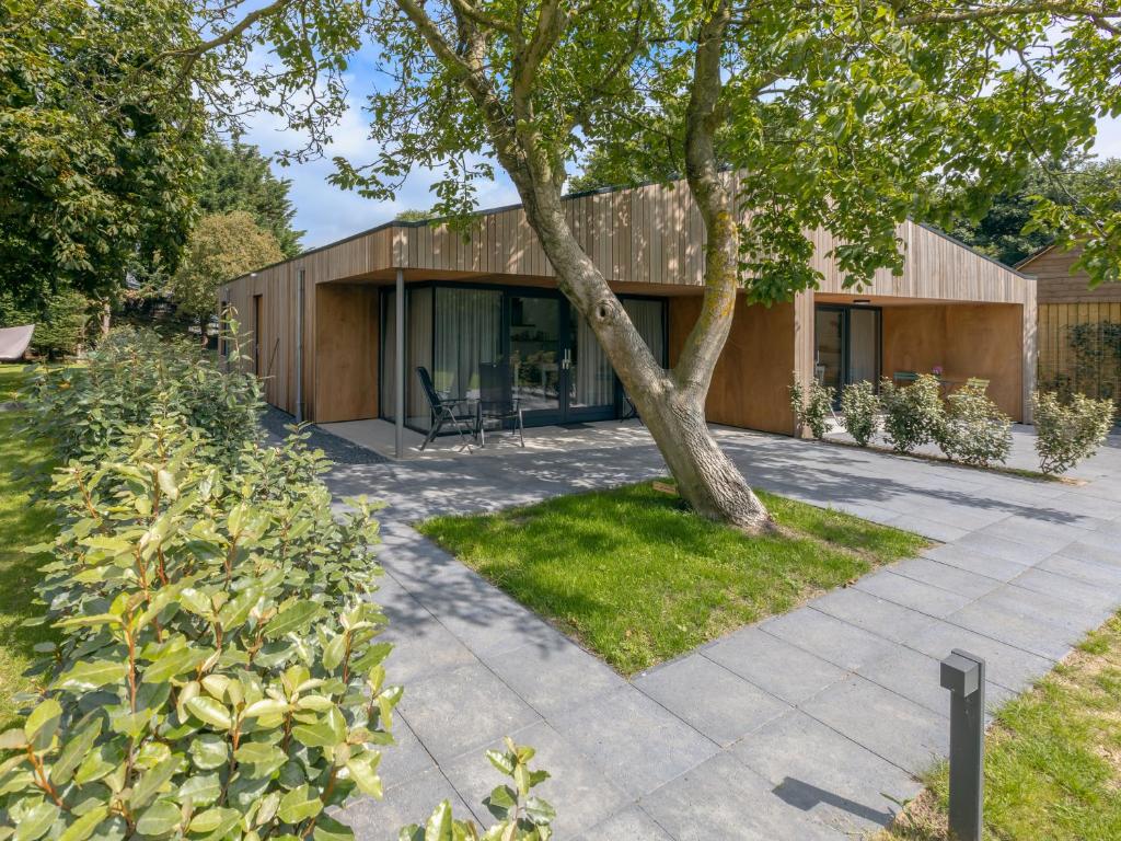 a house with a tree in front of it at De Duinlopers - Studio appt Bries - Duinen, strand en nabij cultuur steden in Castricum