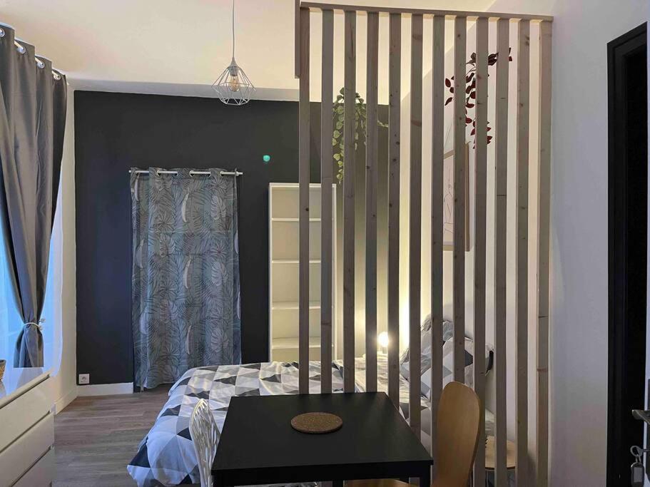 a bedroom with a bed and a table in it at La douce chambrée de Guingamp in Guingamp