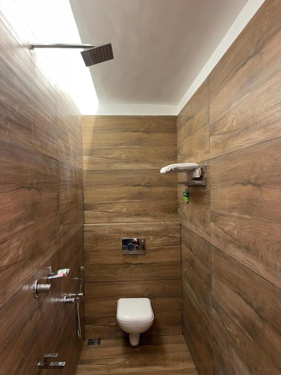 uma casa de banho com WC e paredes de madeira em Whitehouse Residency em Palakkad