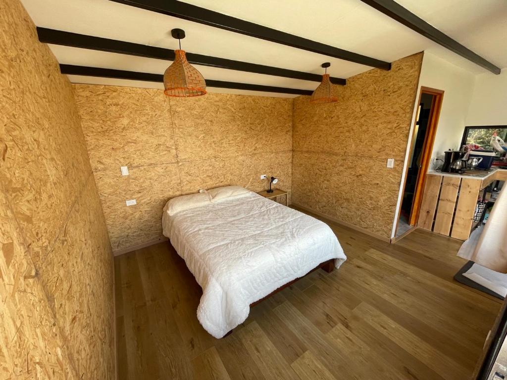 1 dormitorio con 1 cama blanca en una habitación en Cabaña Rural con excelente vista en Duitama