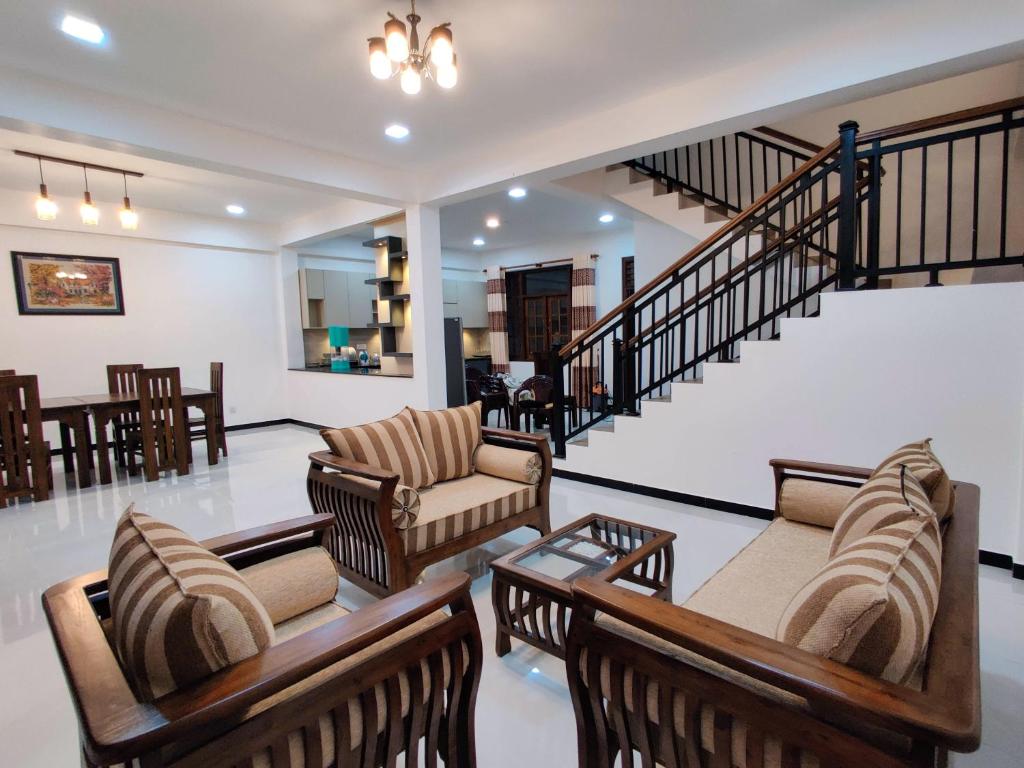 a living room with couches and a staircase at Highway Twin Home East wing in Kadawatha
