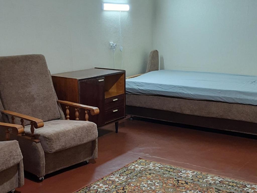 1 dormitorio con 1 cama, vestidor y silla en Эконом вариант - спальный район, en Cherníhiv