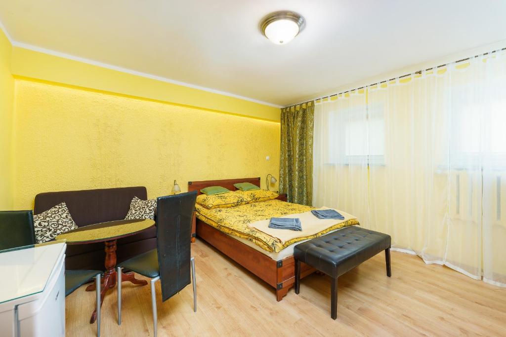 科沃布熱格的住宿－Pokoje Gościnne Pod Różą，卧室配有一张床和一张桌子及椅子