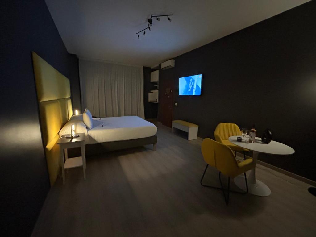 バーリにあるB＆B バチアミ アンコラのベッド、テーブル、椅子が備わるホテルルームです。