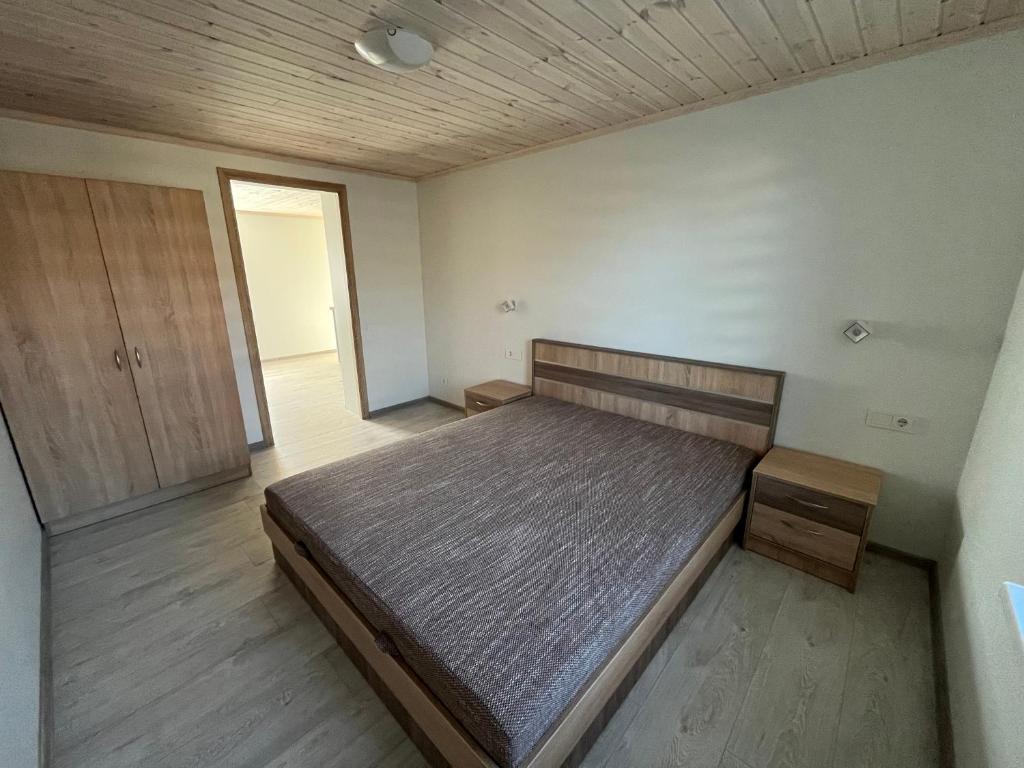 1 dormitorio con 1 cama y suelo de madera en SKA Anykščiai, en Anykščiai