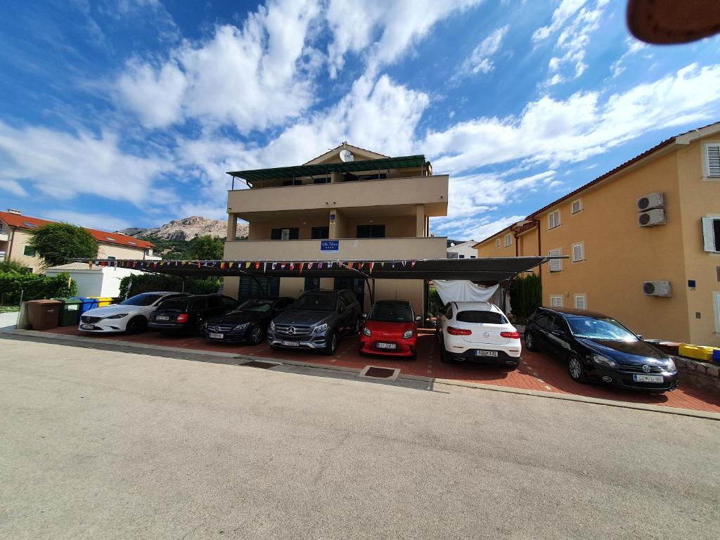 a parking lot with cars parked in front of a building at Apartments Mirica in Baška