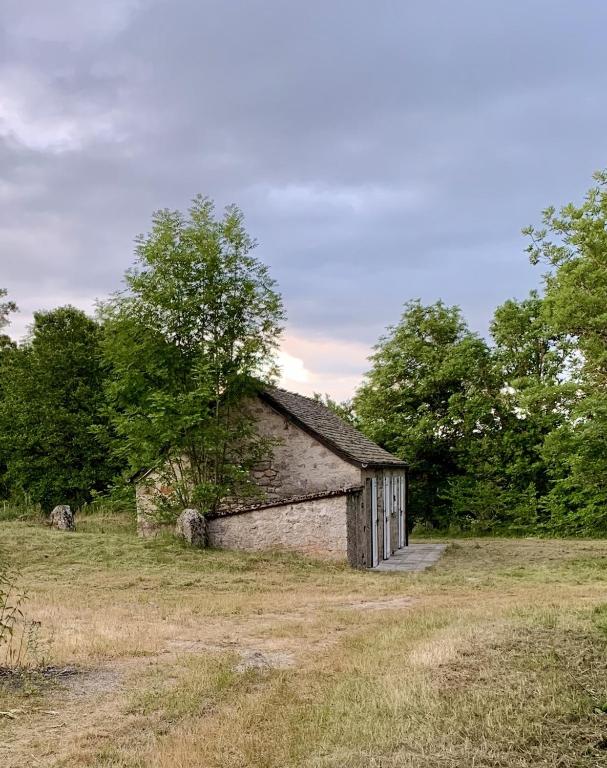 une ancienne grange en pierre assise dans un champ dans l'établissement Adorable petite maison en pleine nature, à Javols