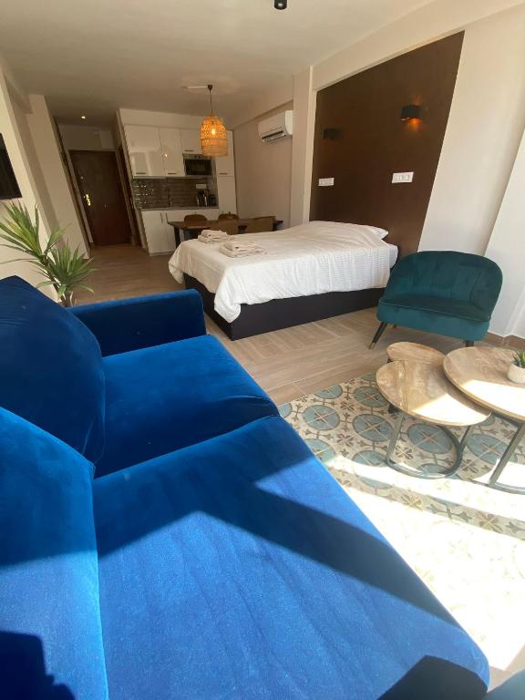 a living room with a blue couch and a bed at Studio Don Jim Family, Beautiful luxurious new Studio near Arenal beach in Jávea