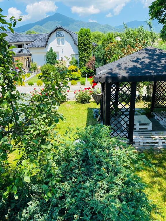 a garden with a gazebo and a house at Agropa Rooms & Garden Events in Bistriţa