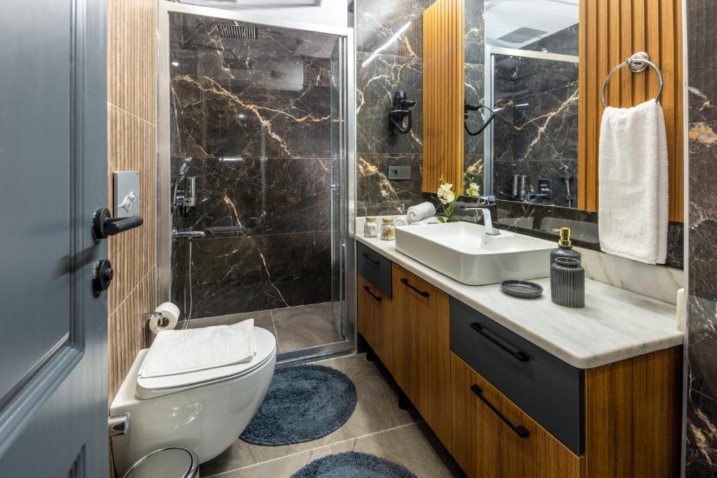 a bathroom with a toilet and a sink and a shower at Baymari Suites Design Florya in Istanbul