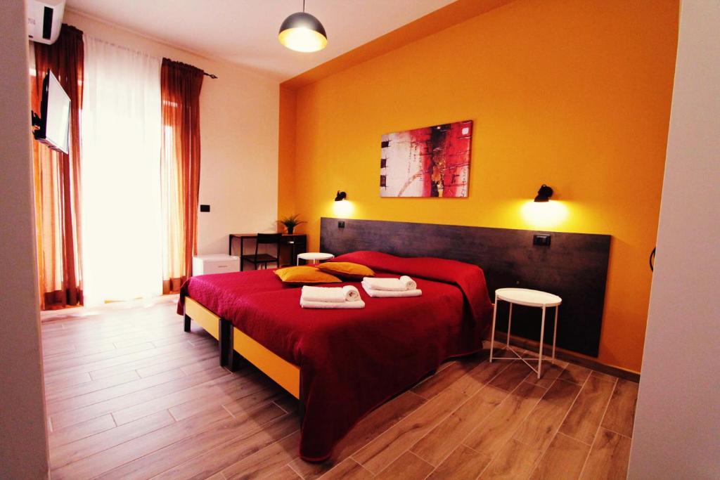 a bedroom with a red bed and yellow walls at OLTREMARE in Scalea