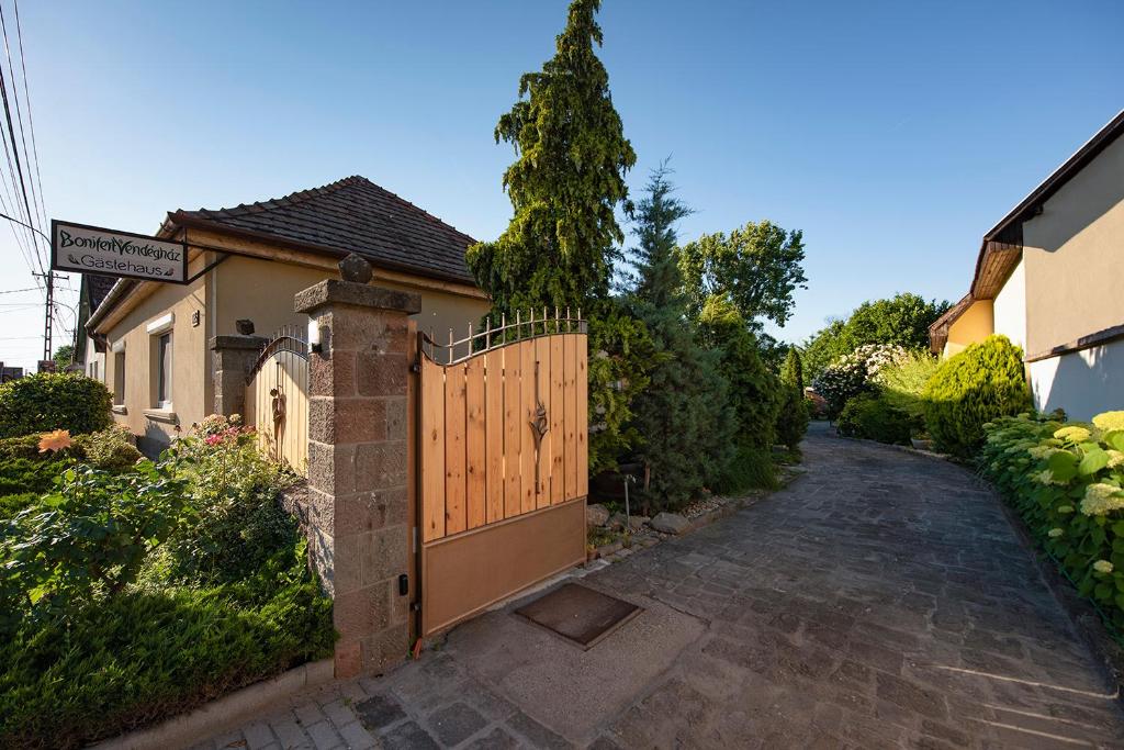 uma casa com um portão de madeira ao lado de uma entrada em Bonifert Vendégház em Dunabogdány