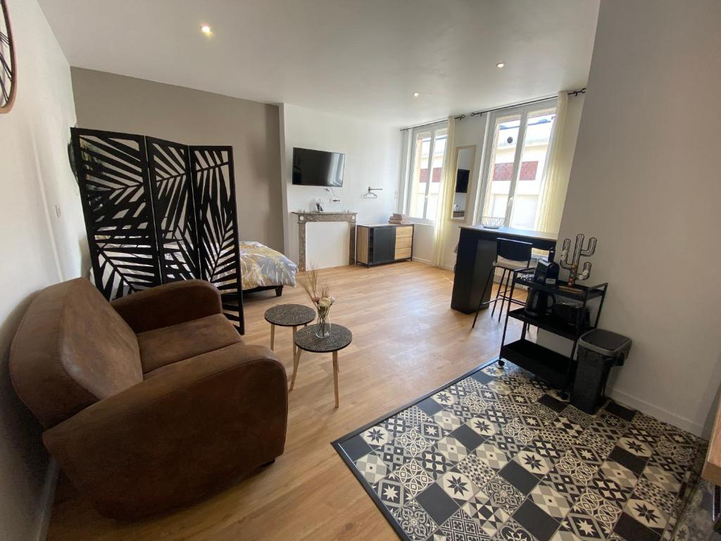 ein Wohnzimmer mit einem Sofa und einem Tisch in der Unterkunft Brown Cosy in Louviers
