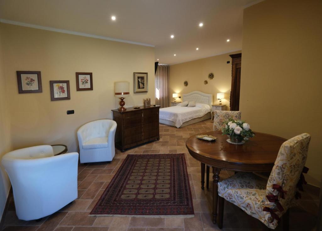 une chambre d'hôtel avec un lit, une table et des chaises dans l'établissement Tenuta Aranuova, à Verceil