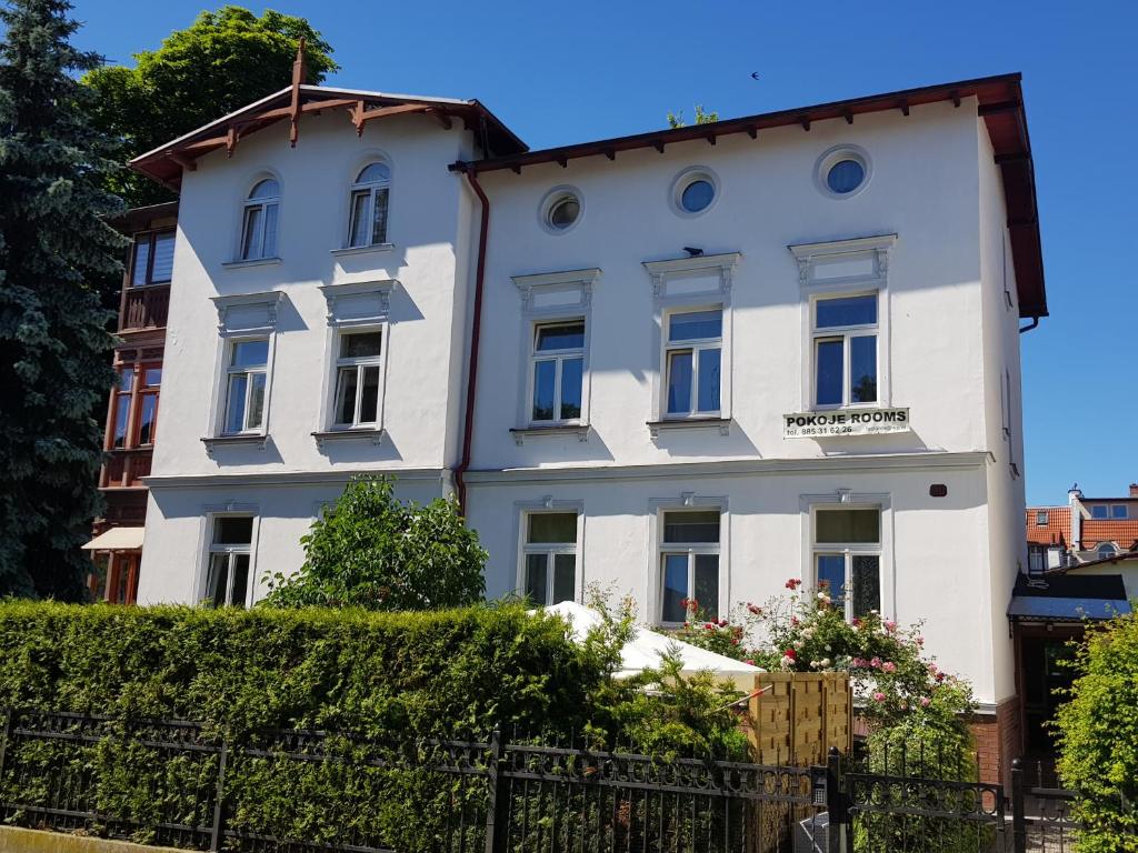 a white building with blue windows at Sopot Roza Apartments in Sopot