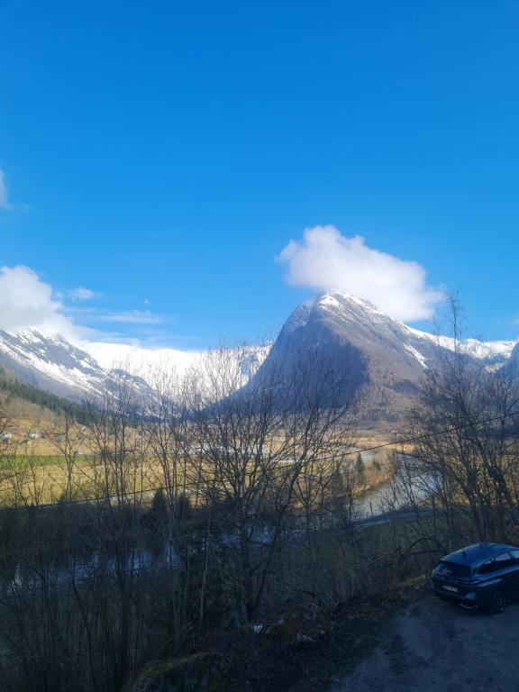 un coche aparcado frente a una montaña cubierta de nieve en Fjærland Våteviksvegen 17 en Bøyum