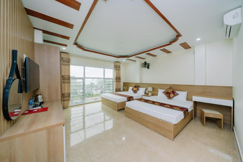 um quarto amplo com 2 camas e uma televisão de ecrã plano em Cat Ba My Ngoc View Hotel em Ilha de Cát Bà