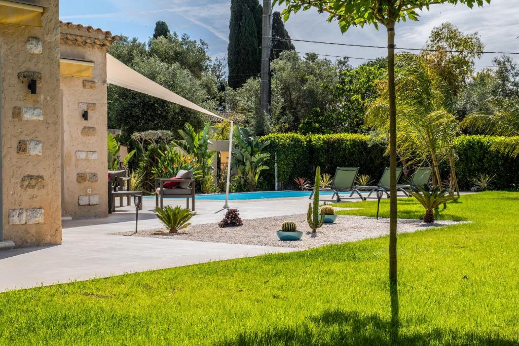 a garden with a swimming pool and green grass at SERRENDY Calm family house with swimming pool in Antibes