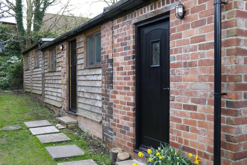 a brick house with a black door on it at Cottage - Sleeps 2 - Garden - Parking in Ryton