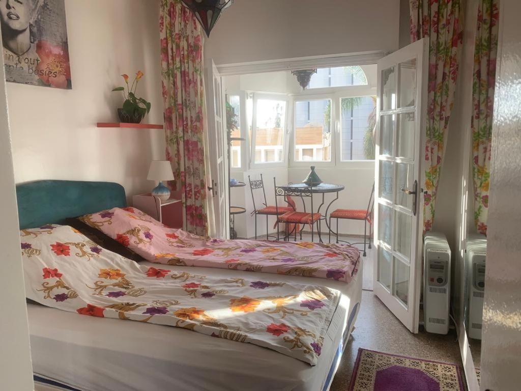 阿加迪爾的住宿－Appartment Avenue Hassan II，一间卧室设有一张床、一个窗口和一张桌子