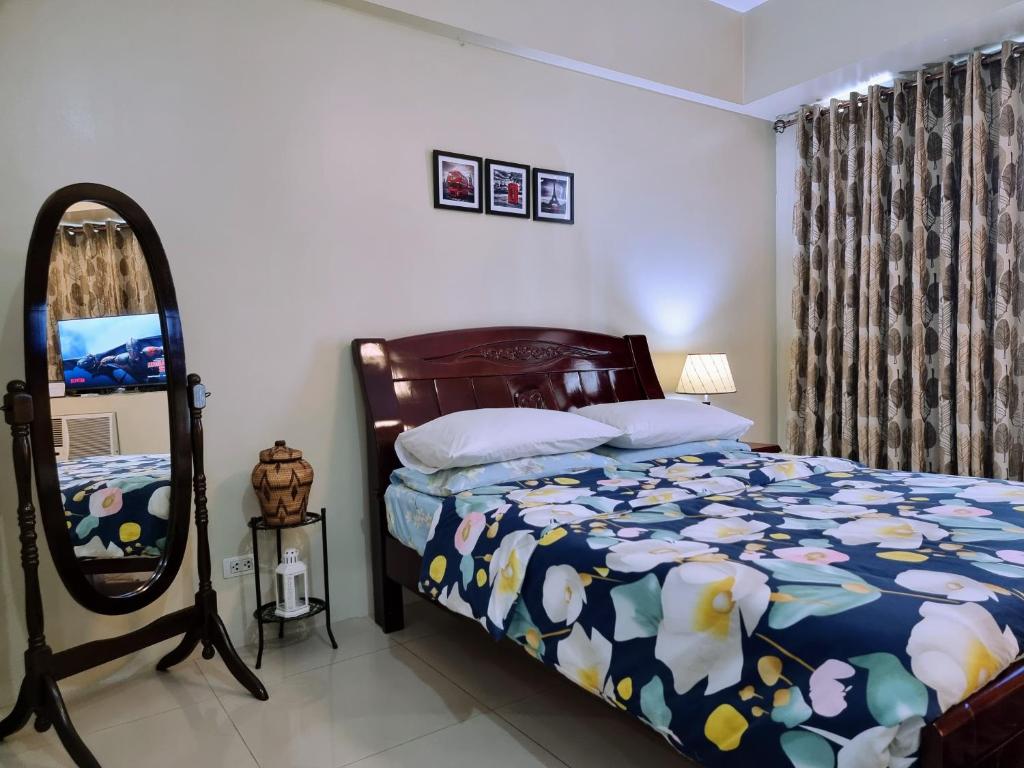 Schlafzimmer mit einem Bett und einem Spiegel in der Unterkunft One Palm Tree Villas Condo Across NAIA Terminal 3 in Manila