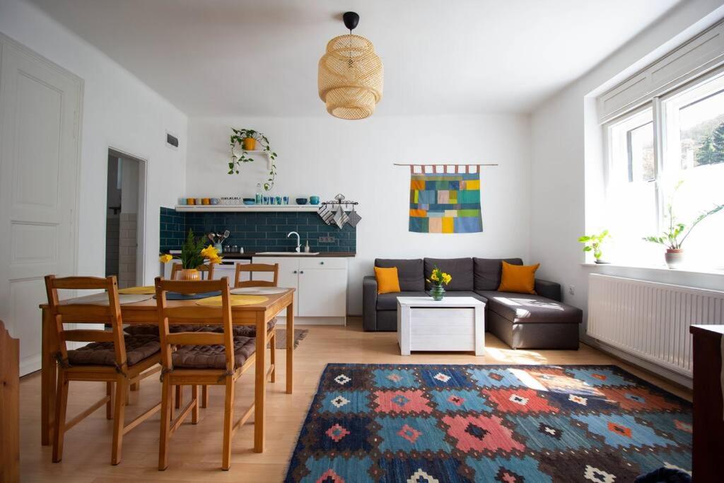 a living room with a dining table and a kitchen at Diófa Vendégház, Zebegény in Zebegény