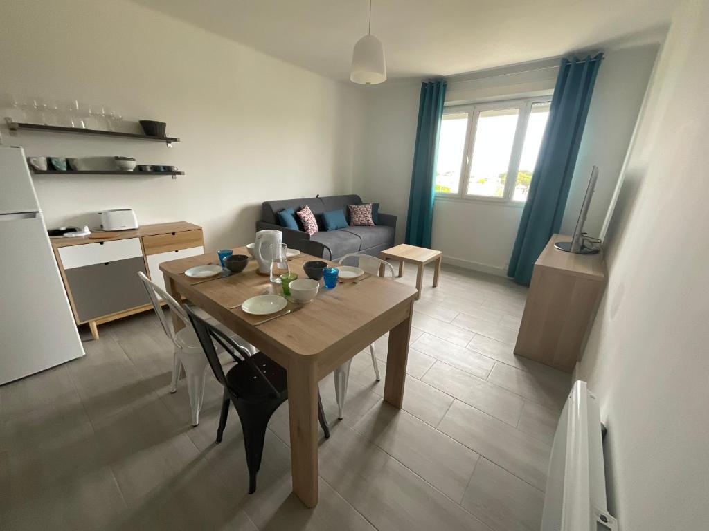 een keuken en een woonkamer met een tafel en een bank bij ENTRE MER ET ARENE in Le Grau-du-Roi