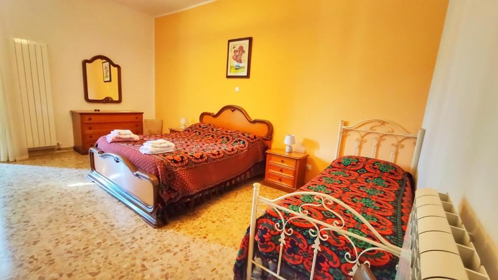 um quarto com 2 camas, uma cómoda e um espelho em Nonna Domenica - Casa Vacanze @Gagliano Aterno em Gagliano Aterno