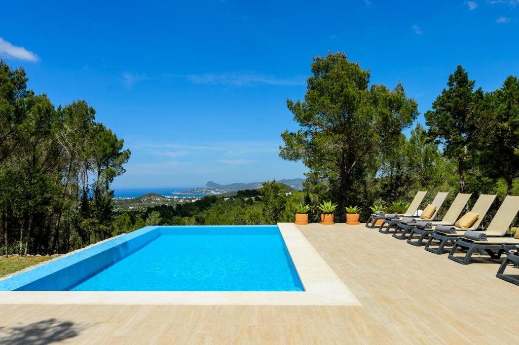 una piscina con tumbonas y una piscina en Villa Can Rafalet, en Sant Josep de sa Talaia
